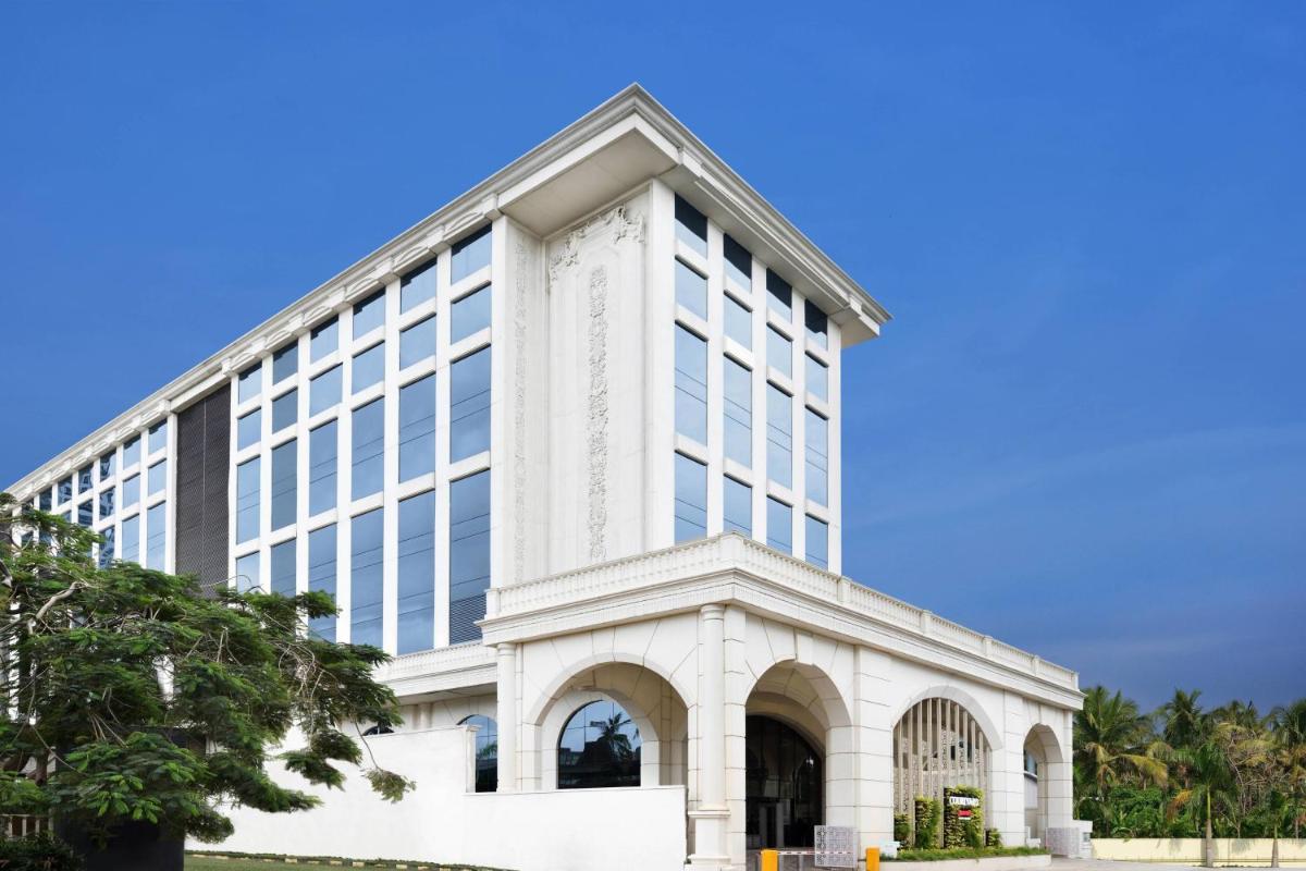 a large white building with windows on a blue sky at Courtyard by Marriott Bengaluru Hebbal in Bengaluru