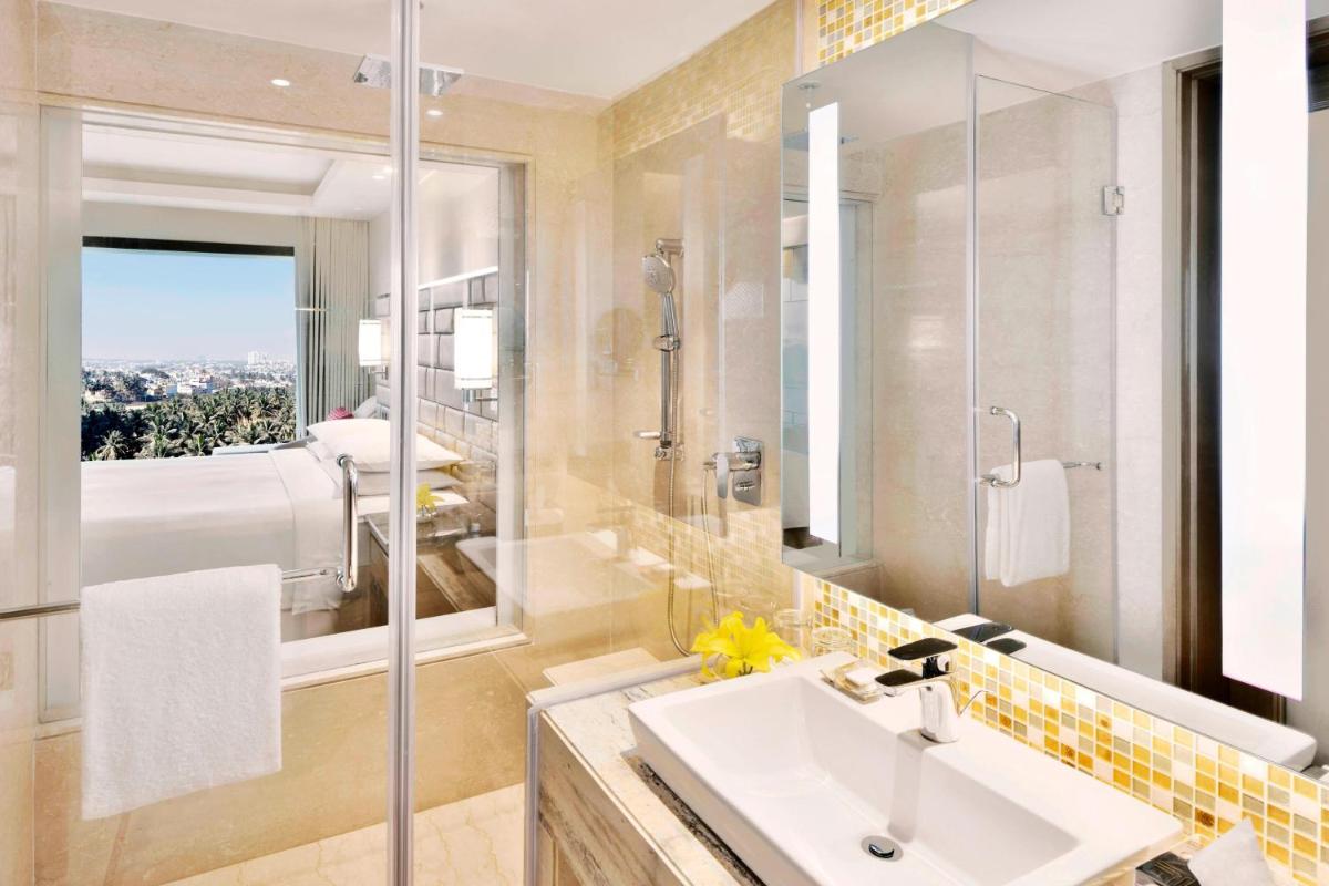 a bathroom with a sink and a large mirror at Courtyard by Marriott Bengaluru Hebbal in Bengaluru a bathroom with a sink and a large mirror at Courtyard by Marriott Bengaluru Hebbal in Bengaluru