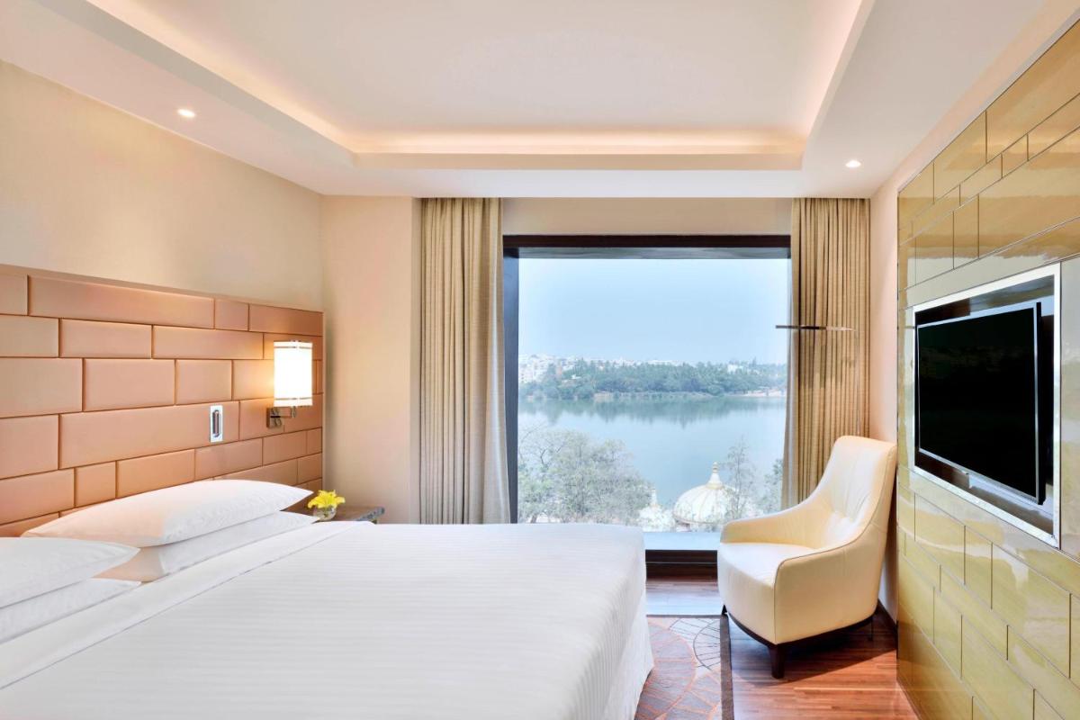 a hotel room with two beds and a large window at Courtyard by Marriott Bengaluru Hebbal in Bengaluru