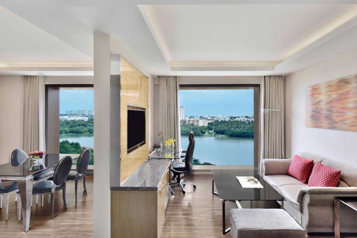 a living room with a couch and a table with chairs at Courtyard by Marriott Bengaluru Hebbal in Bengaluru