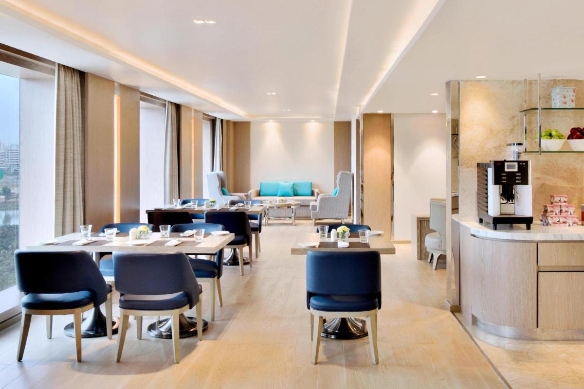 a restaurant with tables and chairs and a bar at Courtyard by Marriott Bengaluru Hebbal in Bengaluru