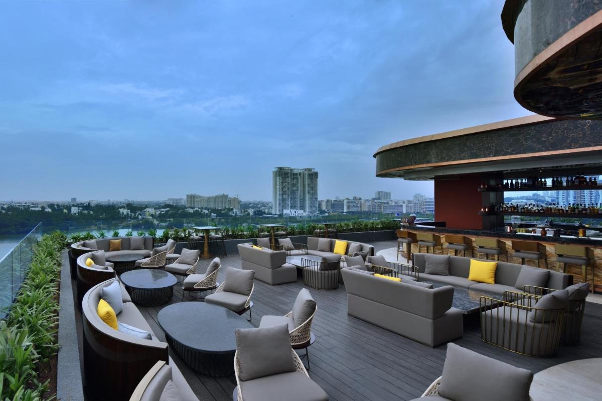 a rooftop bar with couches and tables on a building at Courtyard by Marriott Bengaluru Hebbal in Bengaluru