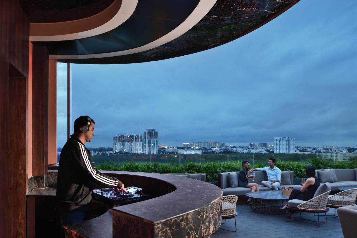 a man standing next to a table in a building at Courtyard by Marriott Bengaluru Hebbal in Bengaluru