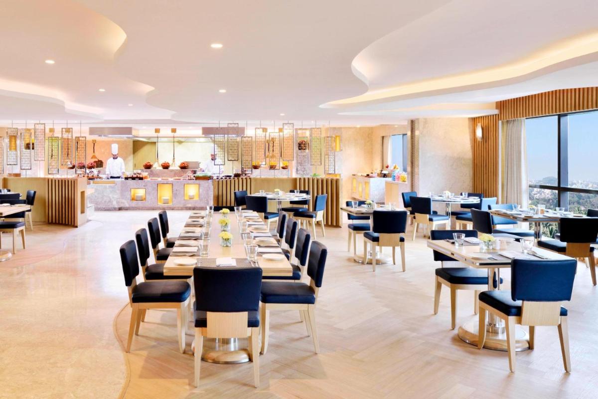 a dining room with a long table and chairs at Courtyard by Marriott Bengaluru Hebbal in Bengaluru