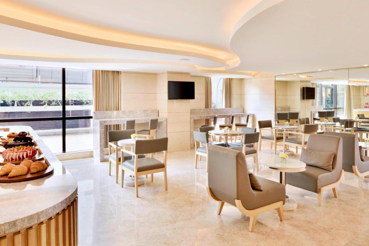a restaurant with tables and chairs and a bar at Courtyard by Marriott Bengaluru Hebbal in Bengaluru
