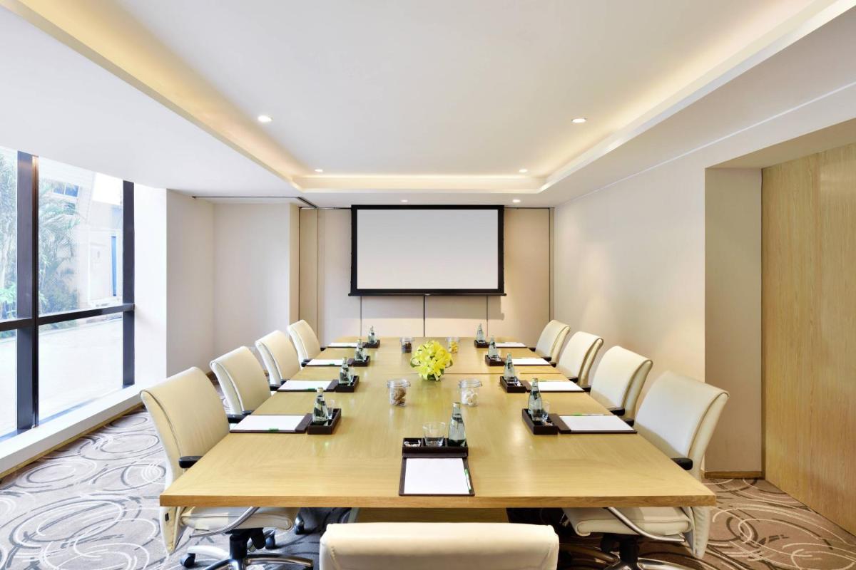 a conference room with a large table and chairs at Courtyard by Marriott Bengaluru Hebbal in Bengaluru