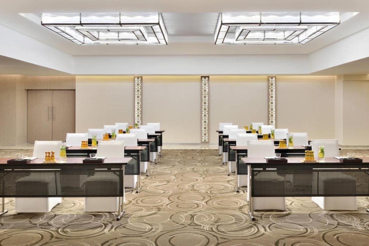 a room with rows of tables and chairs at Courtyard by Marriott Bengaluru Hebbal in Bengaluru