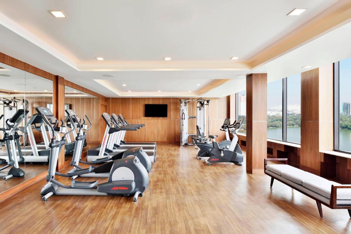a gym with treadmills and elliptical machines at Courtyard by Marriott Bengaluru Hebbal in Bengaluru