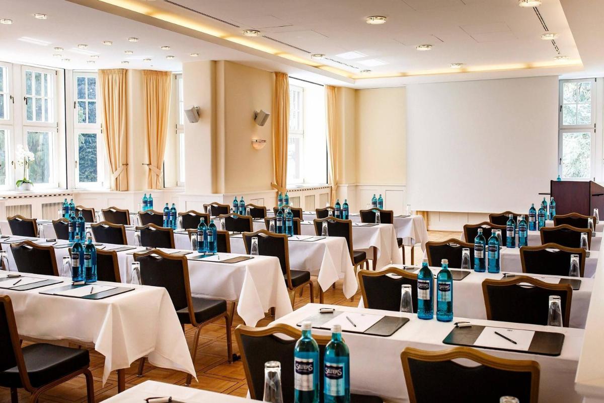 ein Zimmer mit Tischen und Stühlen mit blauen Flaschen darauf in der Unterkunft Falkenstein Grand, Autograph Collection in Königstein im Taunus + 37 Fotos ein Zimmer mit Tischen und Stühlen mit blauen Flaschen darauf in der Unterkunft Falkenstein Grand, Autograph Collection in Königstein im Taunus + 37 Fotos