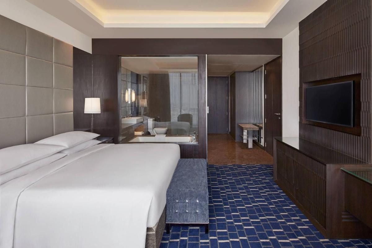 a hotel room with a bed and a television at Renaissance Bengaluru Race Course Hotel in Bengaluru