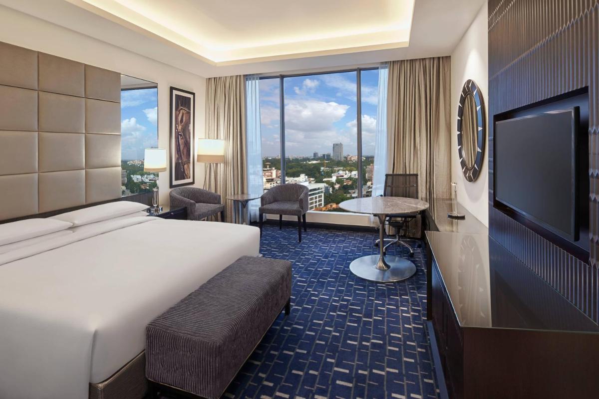 a hotel room with a bed and a large window at Renaissance Bengaluru Race Course Hotel in Bengaluru
