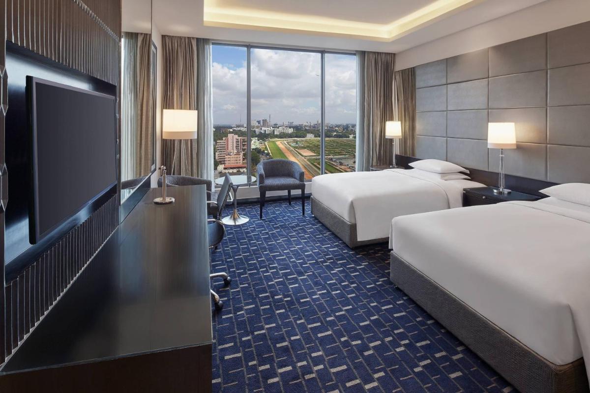 a hotel room with two beds and a flat screen tv at Renaissance Bengaluru Race Course Hotel in Bengaluru