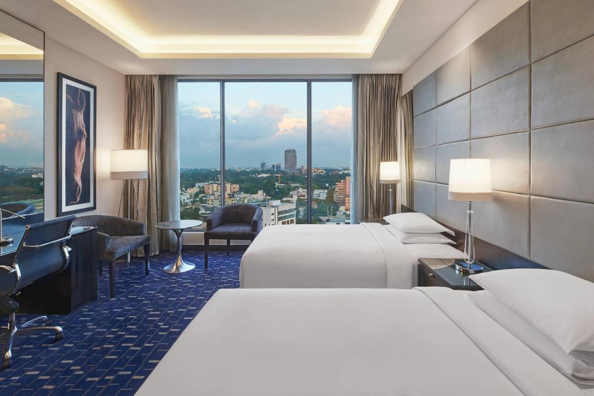 a hotel room with two beds and a large window at Renaissance Bengaluru Race Course Hotel in Bengaluru