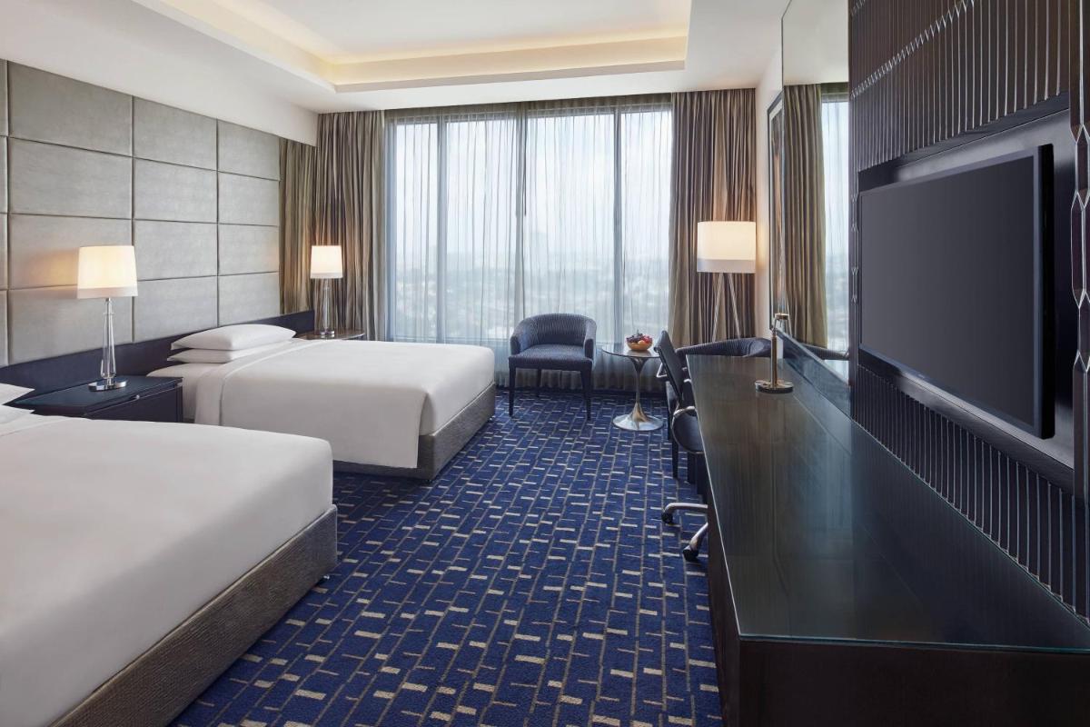 a hotel room with two beds and a flat screen tv at Renaissance Bengaluru Race Course Hotel in Bengaluru