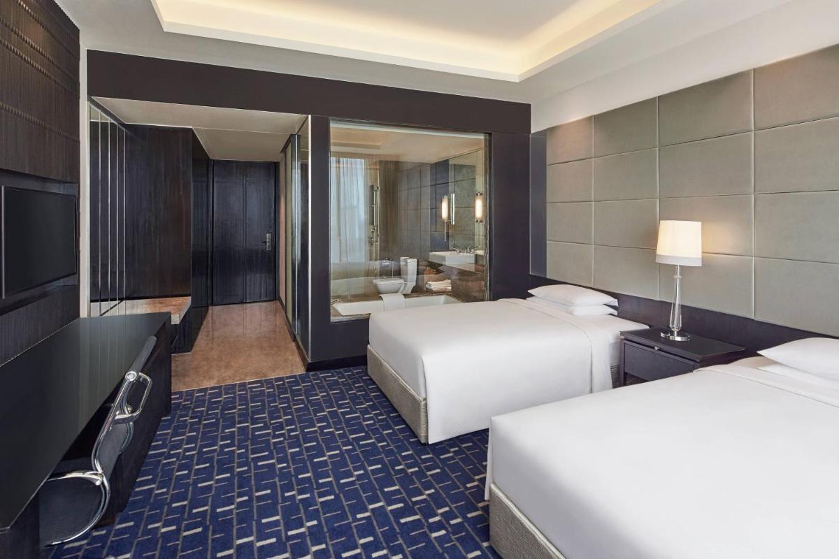 a hotel room with two beds and a bathroom at Renaissance Bengaluru Race Course Hotel in Bengaluru