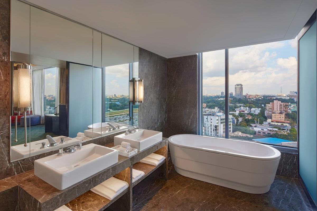 a bathroom with two sinks and a large mirror at Renaissance Bengaluru Race Course Hotel in Bengaluru a bathroom with two sinks and a large mirror at Renaissance Bengaluru Race Course Hotel in Bengaluru