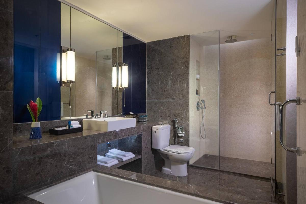 a bathroom with a toilet and a sink and a shower at Renaissance Bengaluru Race Course Hotel in Bengaluru