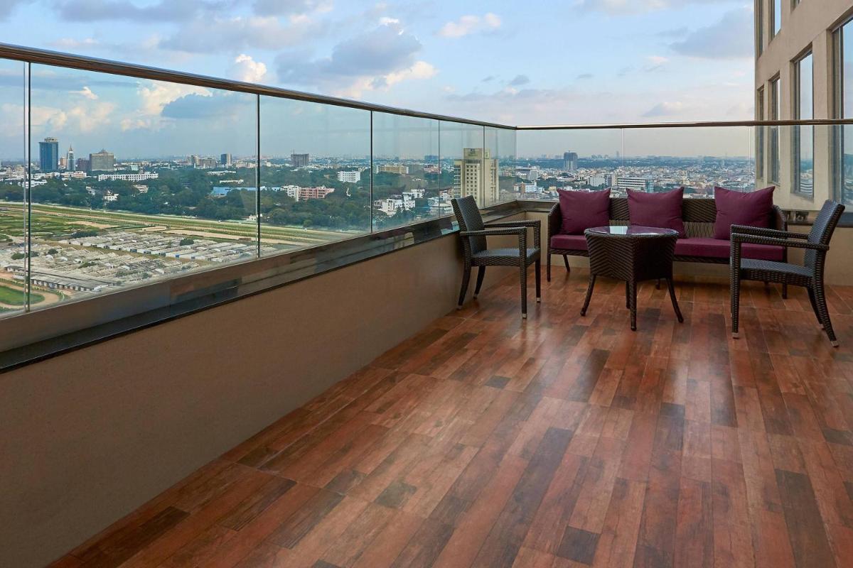 a balcony with a table and chairs on top of a building at Renaissance Bengaluru Race Course Hotel in Bengaluru