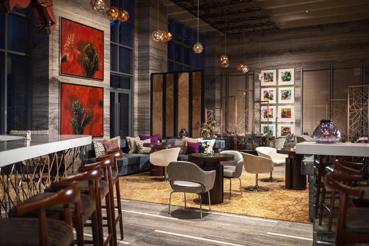 a restaurant with chairs and tables and a lobby at Renaissance Bengaluru Race Course Hotel in Bengaluru