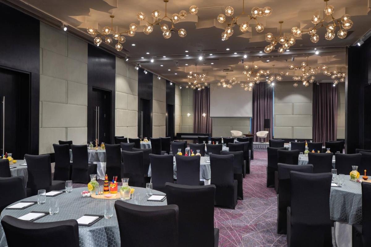 a banquet room with tables and chairs and chandeliers at Renaissance Bengaluru Race Course Hotel in Bengaluru +41 photos