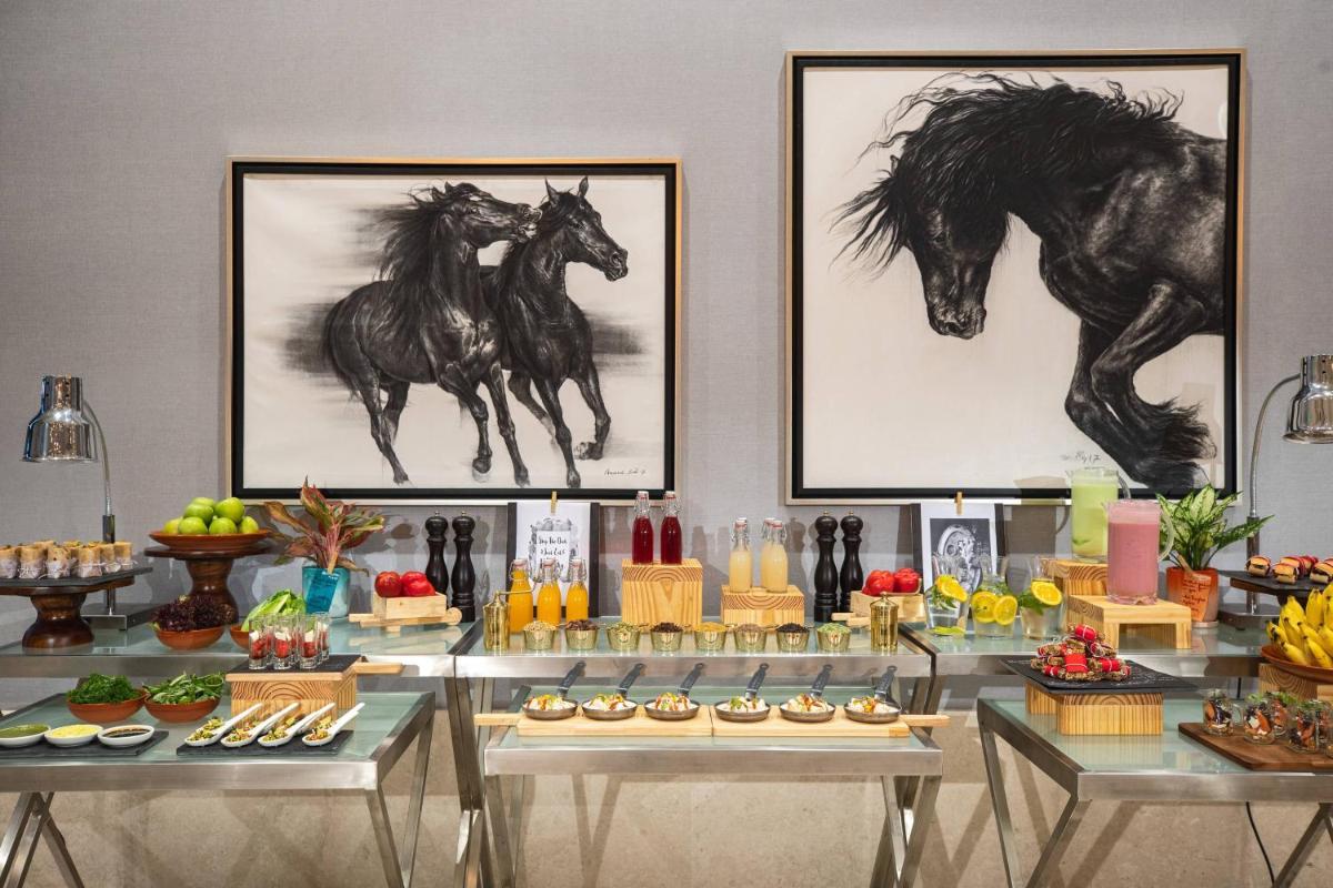 a buffet with two drawings of horses on the wall at Renaissance Bengaluru Race Course Hotel in Bengaluru