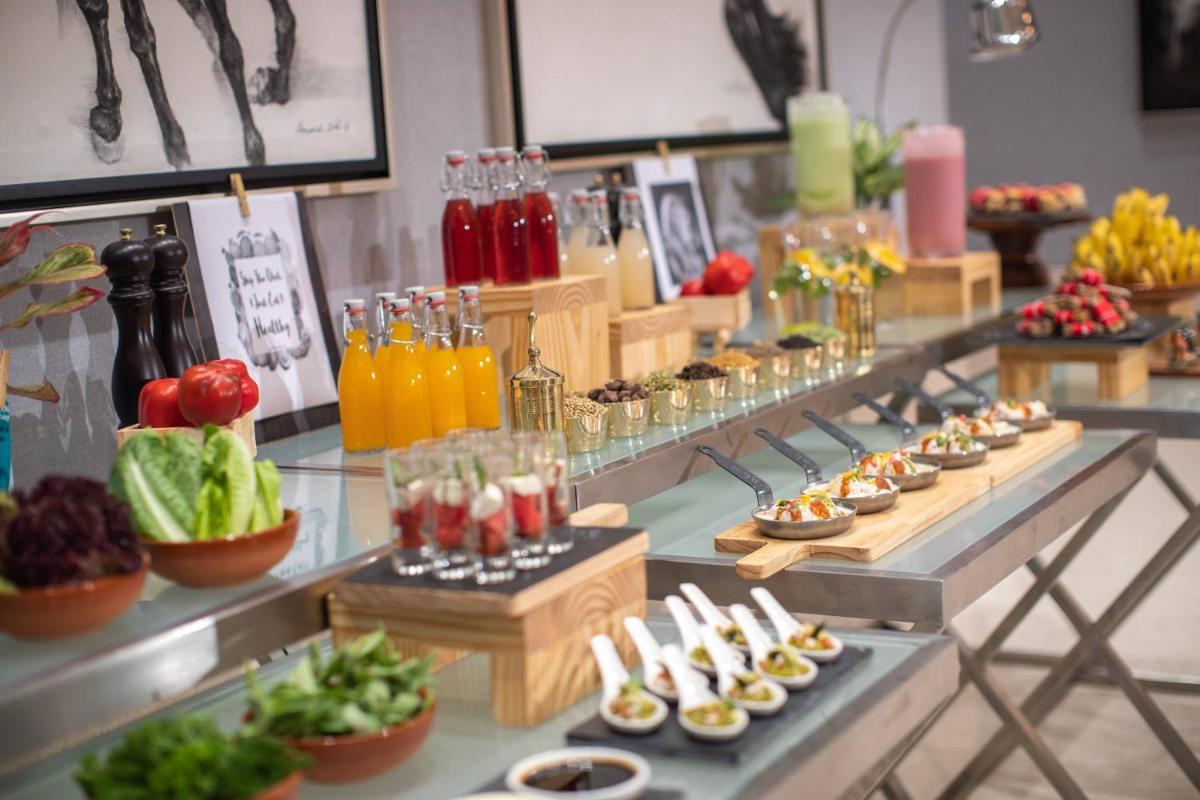 a buffet line with appetizers and drinks on display at Renaissance Bengaluru Race Course Hotel in Bengaluru