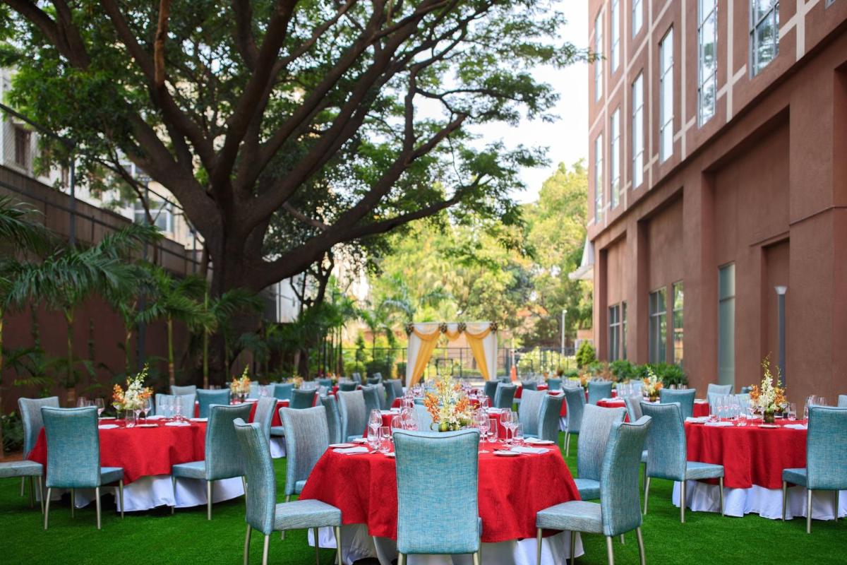 a group of tables and chairs with red and blue table cloth at Renaissance Bengaluru Race Course Hotel in Bengaluru