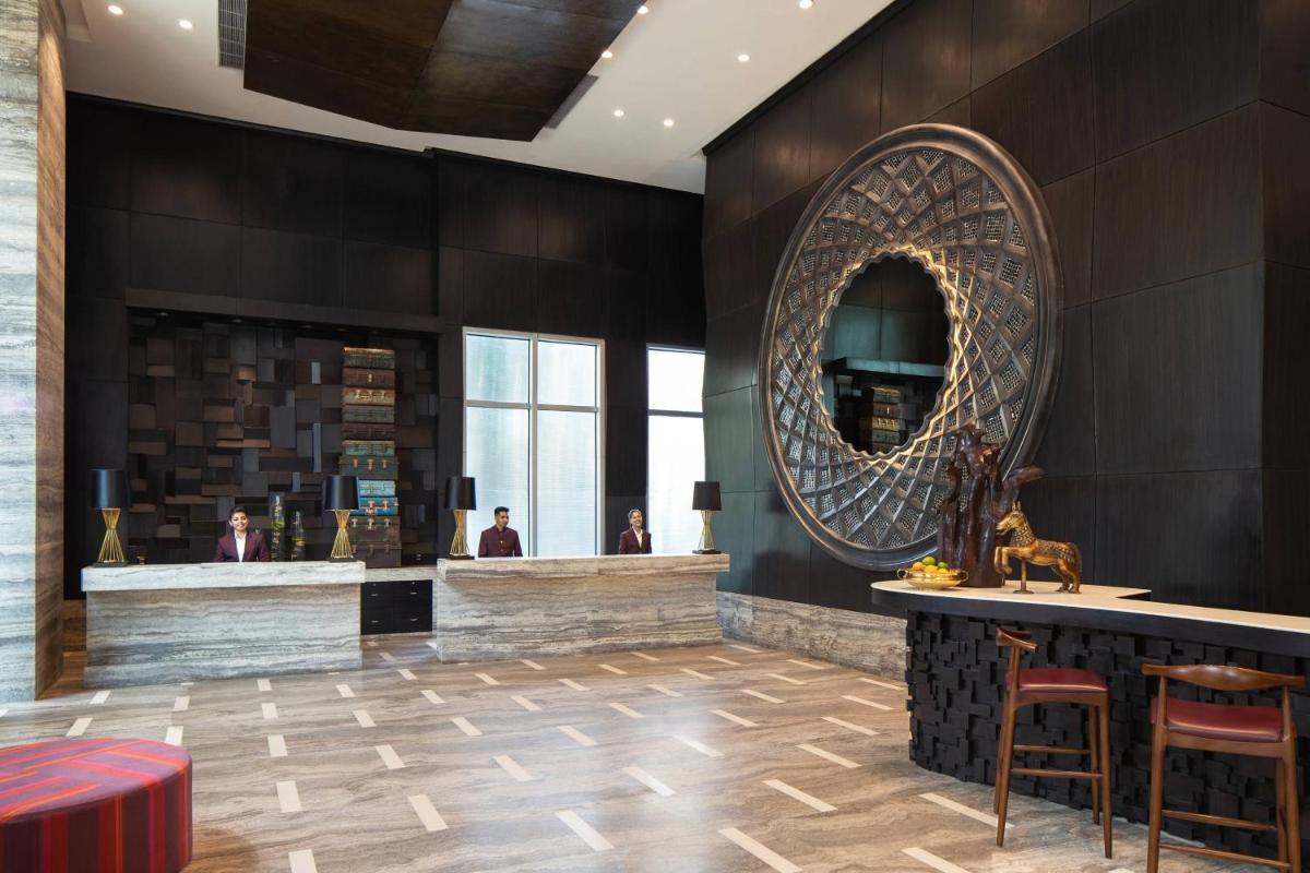 a lobby with a bar and a mirror at Renaissance Bengaluru Race Course Hotel in Bengaluru
