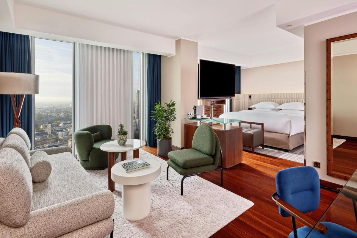 eine Hotelsuite mit Bett und Wohnzimmer in der Unterkunft JW Marriott Hotel Frankfurt in Frankfurt am Main eine Hotelsuite mit Bett und Wohnzimmer in der Unterkunft JW Marriott Hotel Frankfurt in Frankfurt am Main
