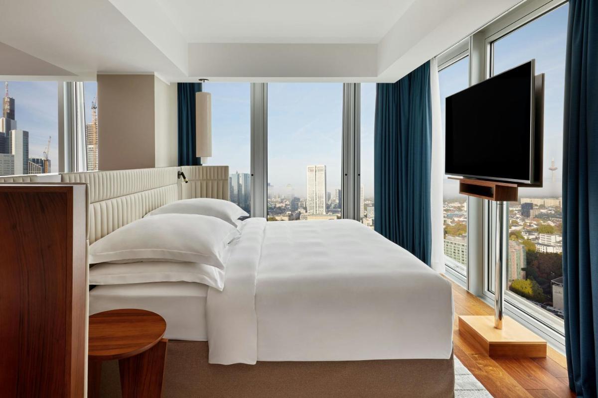 ein Schlafzimmer mit einem großen weißen Bett und großen Fenstern in der Unterkunft JW Marriott Hotel Frankfurt in Frankfurt am Main + 37 Fotos ein Schlafzimmer mit einem großen weißen Bett und großen Fenstern in der Unterkunft JW Marriott Hotel Frankfurt in Frankfurt am Main + 37 Fotos