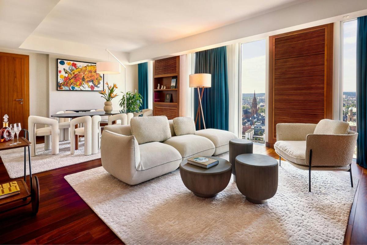 ein Wohnzimmer mit einer Couch und Stühlen und einem Tisch in der Unterkunft JW Marriott Hotel Frankfurt in Frankfurt am Main ein Wohnzimmer mit einer Couch und Stühlen und einem Tisch in der Unterkunft JW Marriott Hotel Frankfurt in Frankfurt am Main