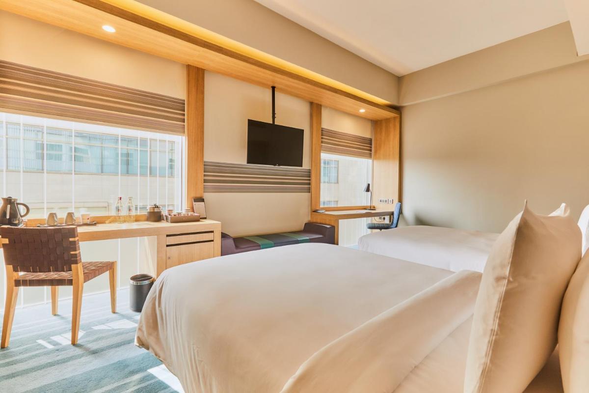 a hotel room with a bed and a desk at Aloft New Delhi Aerocity in New Delhi a hotel room with a bed and a desk at Aloft New Delhi Aerocity in New Delhi