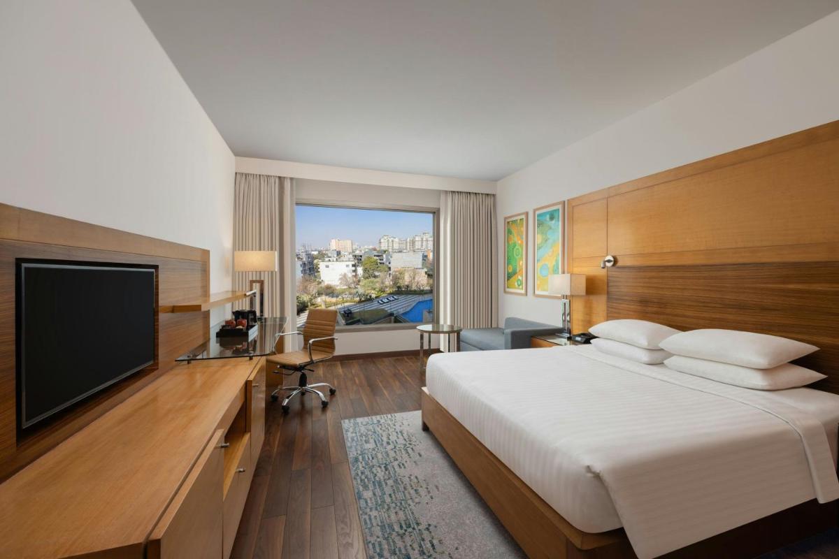a hotel room with a bed and a flat screen tv at Courtyard by Marriott Gurugram Downtown in Gurgaon