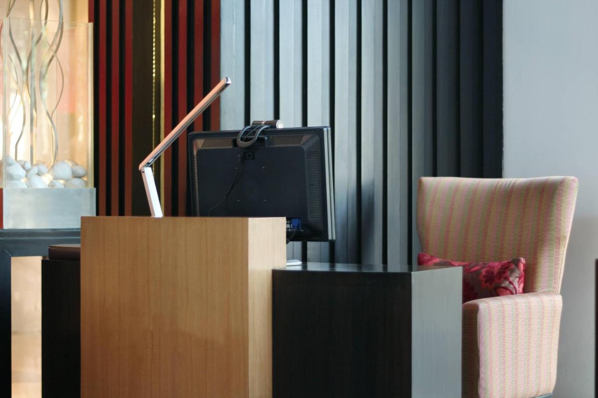 a living room with a tv and a chair at Courtyard by Marriott Gurugram Downtown in Gurgaon