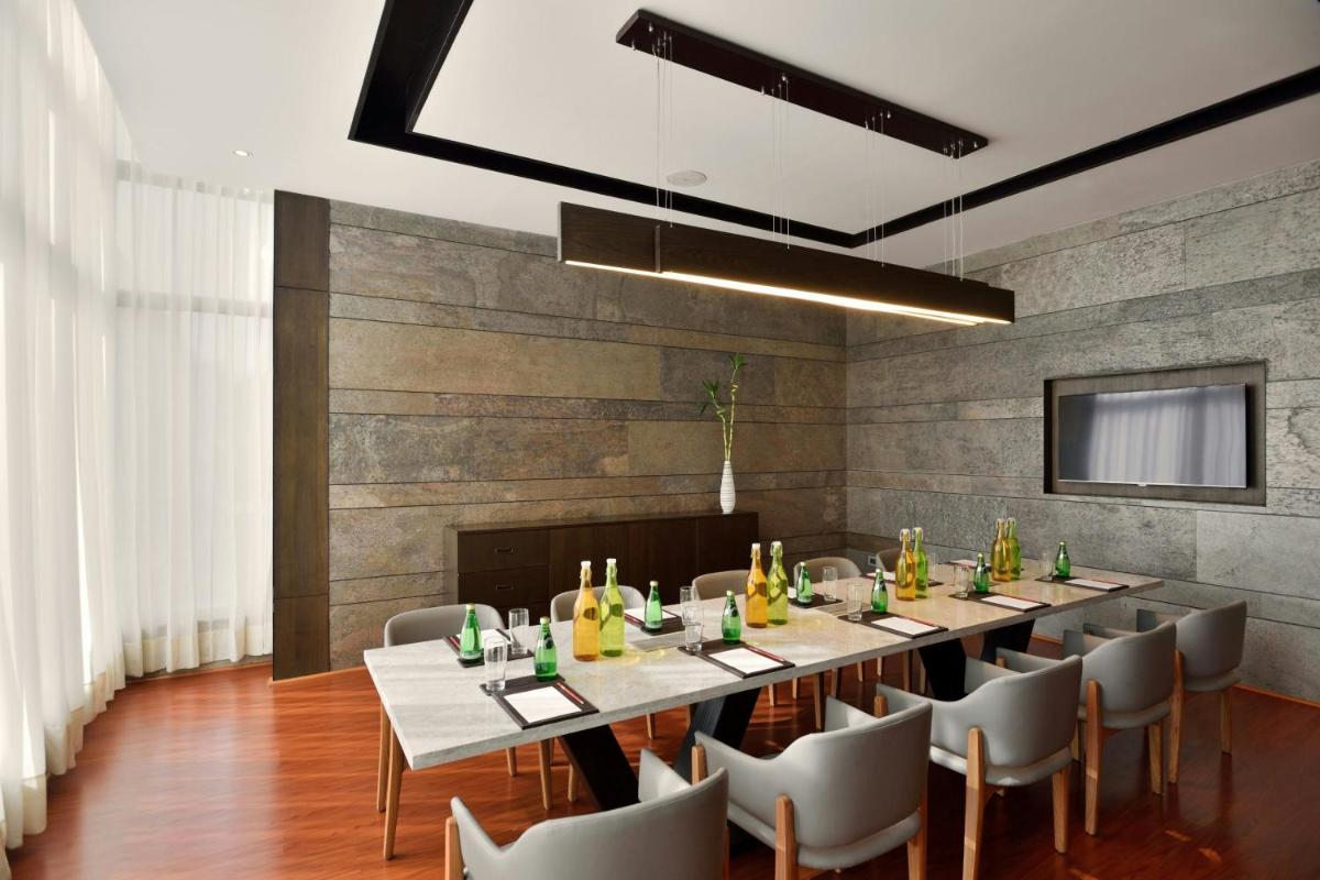 a dining room with a long table and chairs at Courtyard by Marriott Gurugram Downtown in Gurgaon