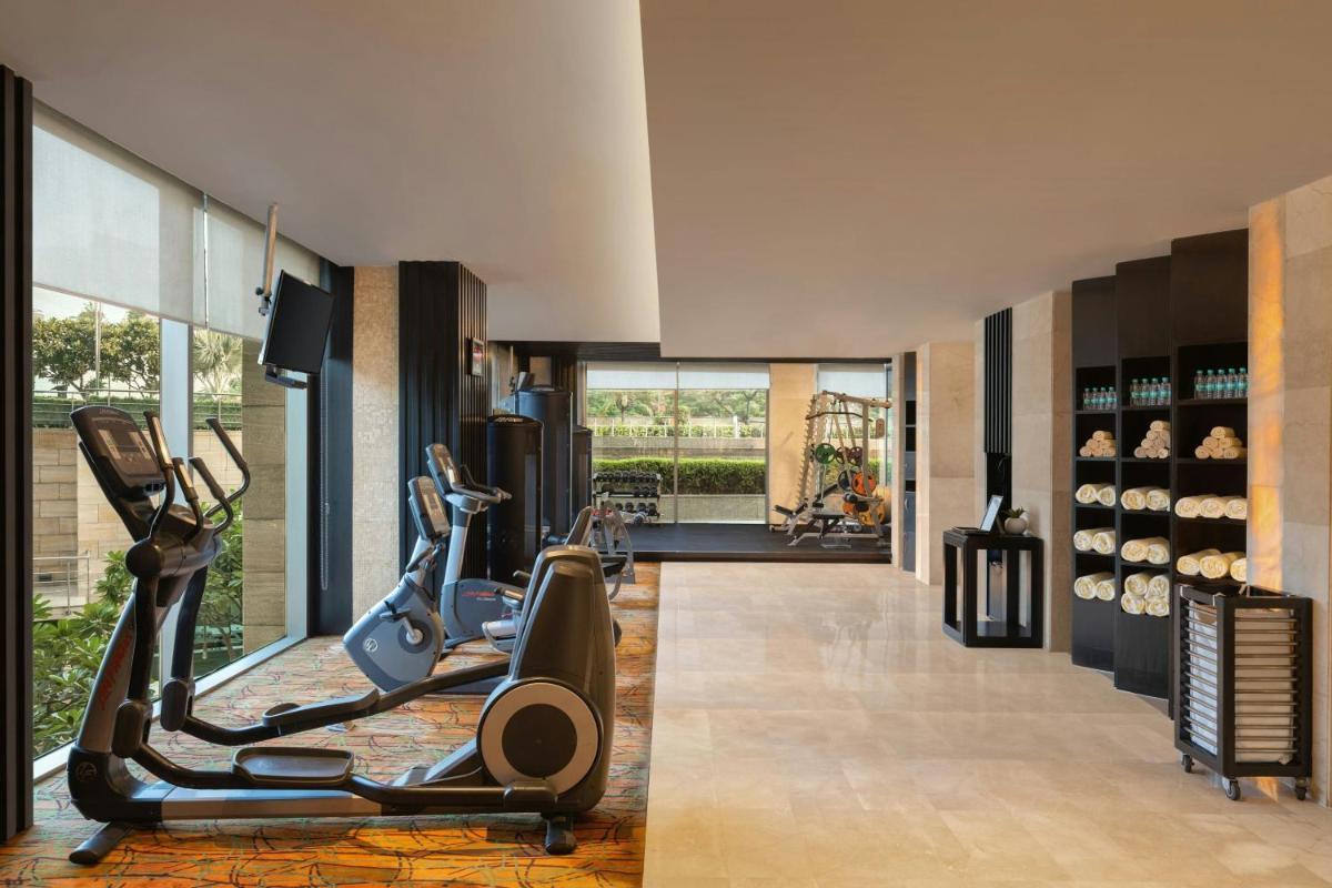 a gym with treadmills and elliptical machines at Courtyard by Marriott Gurugram Downtown in Gurgaon