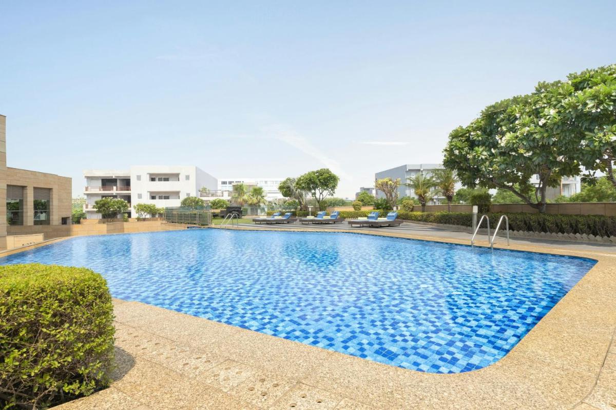 a large blue swimming pool in a building at Courtyard by Marriott Gurugram Downtown in Gurgaon