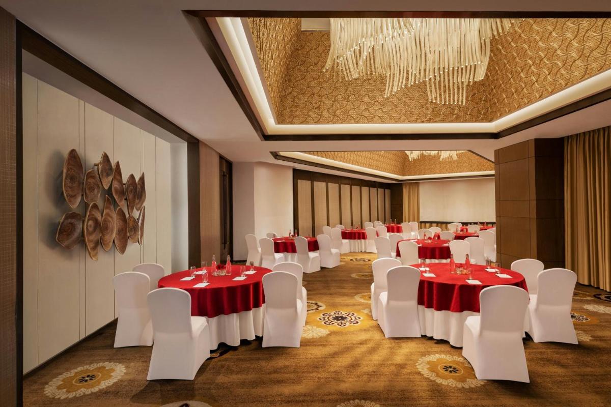 a banquet hall with red and white tables and chairs at Courtyard by Marriott Gurugram Downtown in Gurgaon