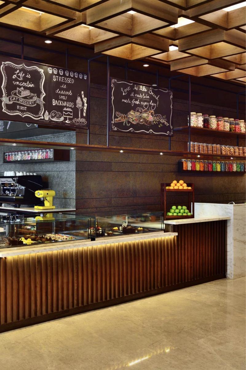 a fast food restaurant with a counter with food at Courtyard by Marriott Gurugram Downtown in Gurgaon