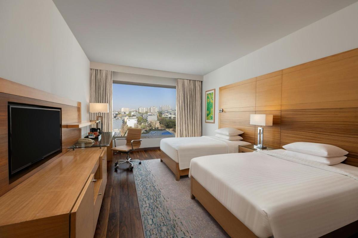a hotel room with two beds and a flat screen tv at Courtyard by Marriott Gurugram Downtown in Gurgaon
