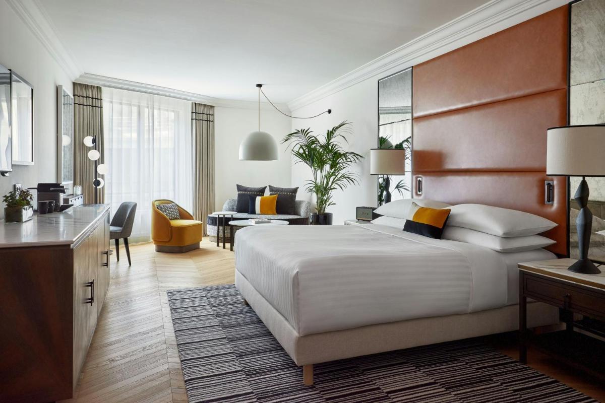 une chambre avec un grand lit et un salon dans l'établissement Paris Marriott Champs Elysees Hotel, à Paris