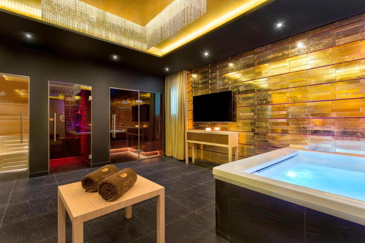 Uma televisão e/ou sistema de entretenimento em Pine Cliffs Ocean Suites, a Luxury Collection Resort & Spa, Algarve