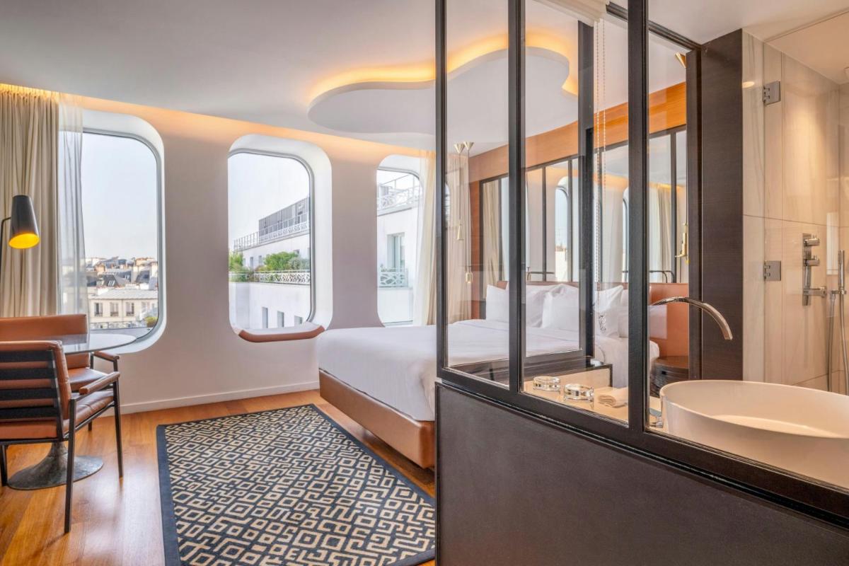 une chambre d'hôtel avec un lit et une baignoire dans l'établissement Renaissance Paris Republique Hotel & Spa, à Paris une chambre d'hôtel avec un lit et une baignoire dans l'établissement Renaissance Paris Republique Hotel & Spa, à Paris