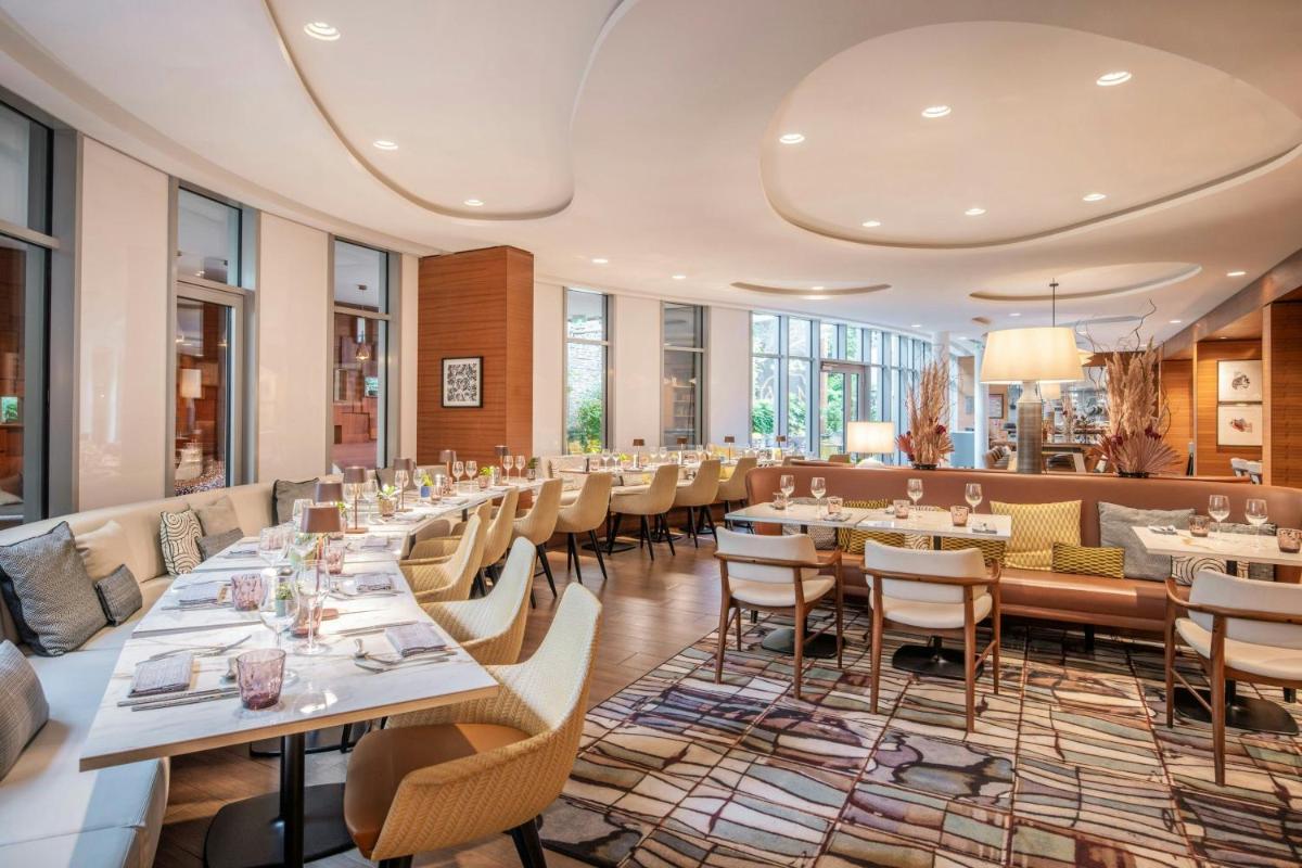 une salle à manger avec tables et chaises dans l'établissement Renaissance Paris Republique Hotel & Spa, à Paris