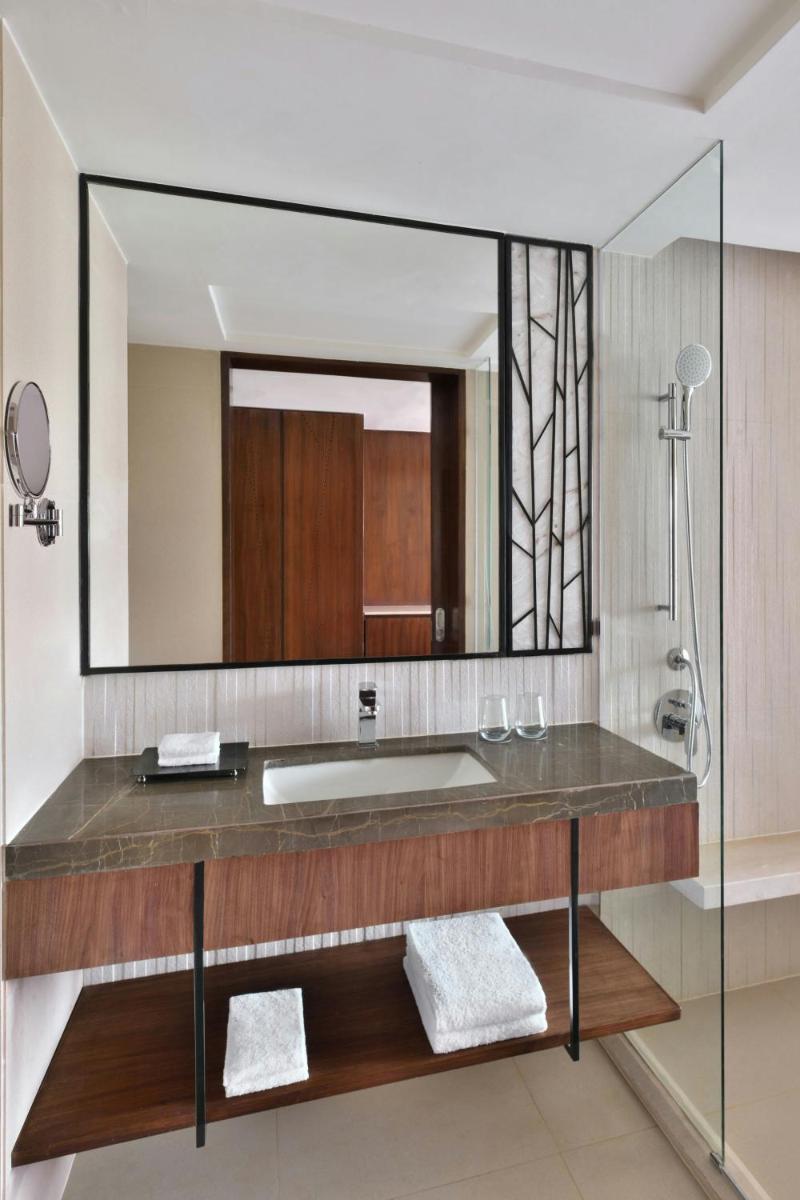 a bathroom with a sink and a large mirror at Courtyard by Marriott Mahabaleshwar in Mahabaleshwar