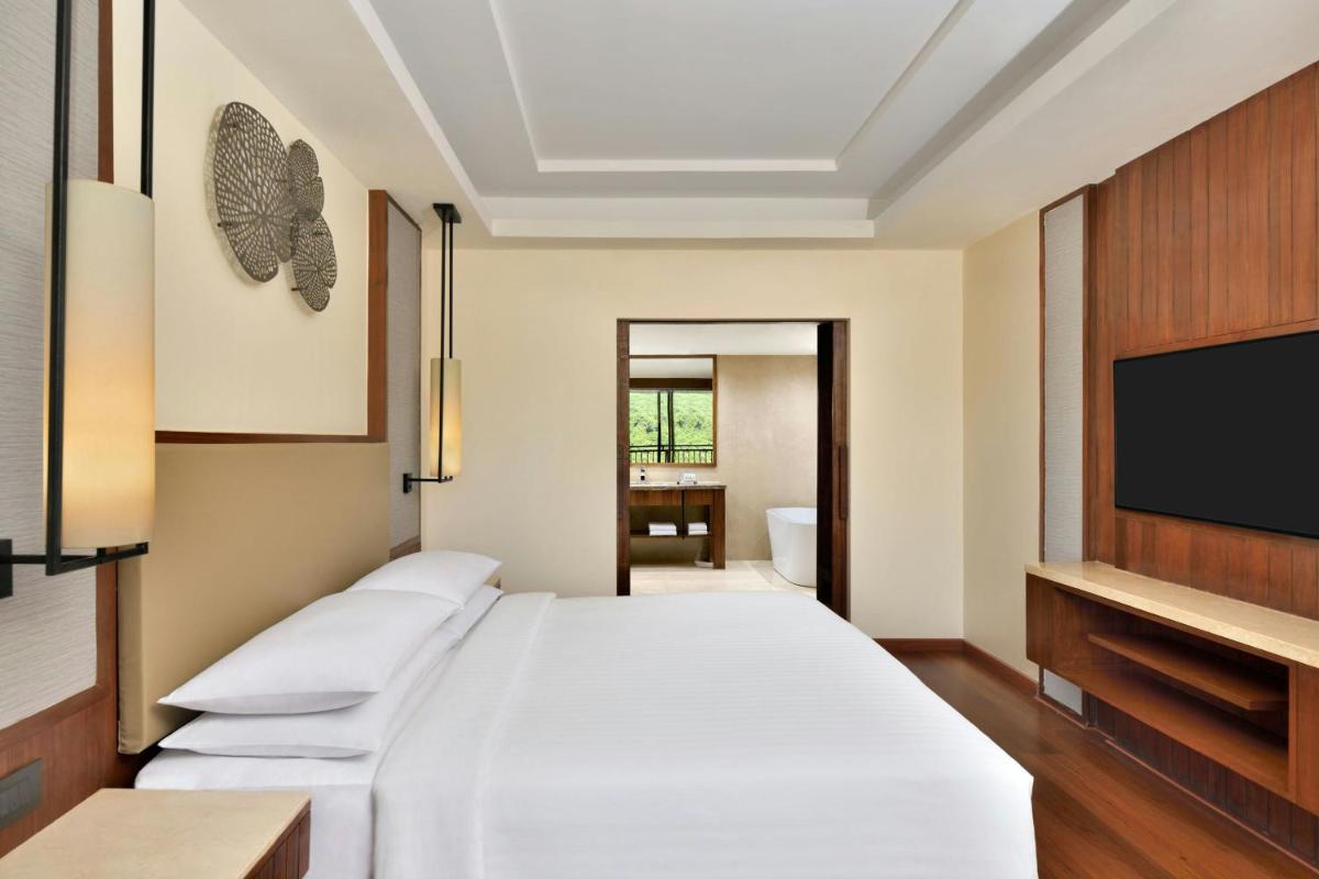 a bedroom with a bed and a flat screen tv at Courtyard by Marriott Mahabaleshwar in Mahabaleshwar