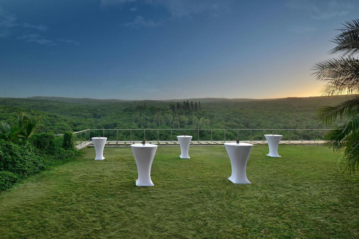 a row of white vases sitting on a field of grass at Courtyard by Marriott Mahabaleshwar in Mahabaleshwar