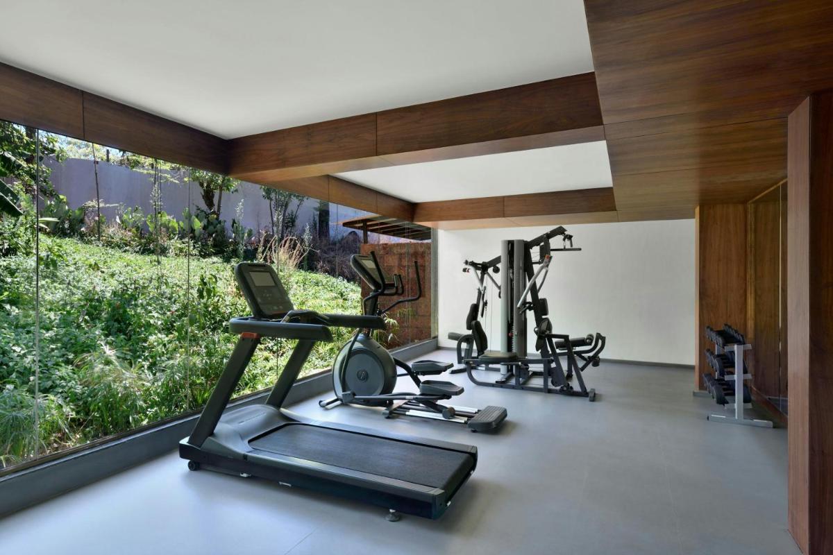 a gym with two treadmills and two exercise bikes at Courtyard by Marriott Mahabaleshwar in Mahabaleshwar