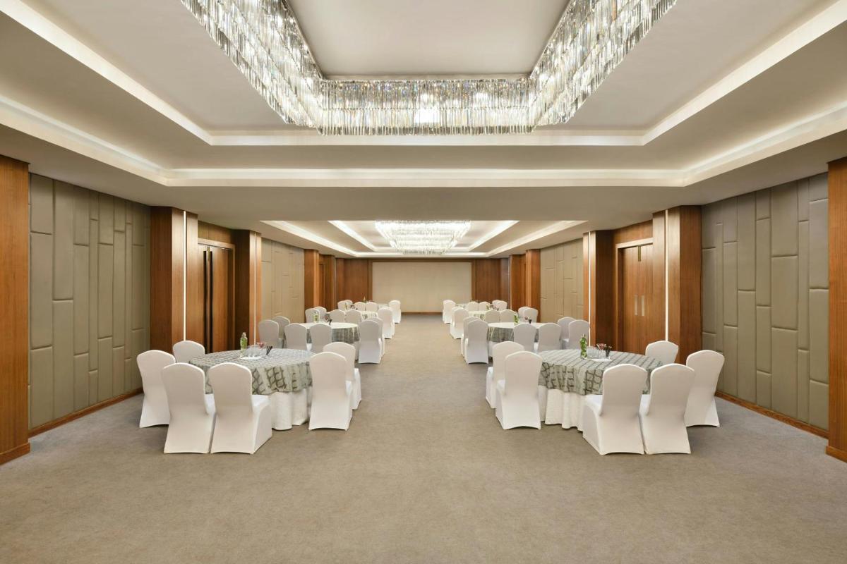 a banquet hall with white tables and white chairs at Courtyard by Marriott Mahabaleshwar in Mahabaleshwar +49 photos