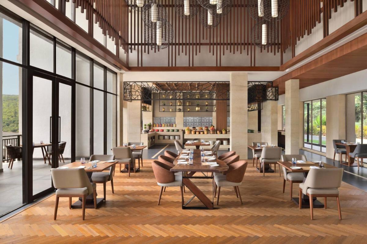 a rendering of a restaurant with tables and chairs at Courtyard by Marriott Mahabaleshwar in Mahabaleshwar